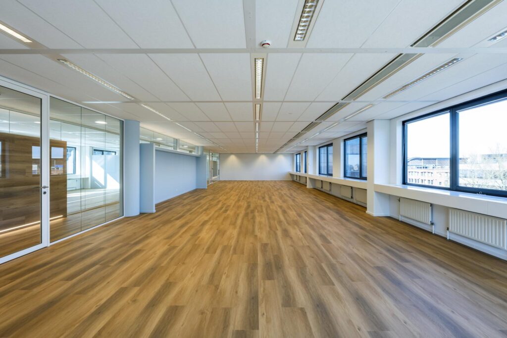 Spacious modern office interior with large windows, wooden flooring, and glass partition walls on Prof. W.H. Keesomlaan.
